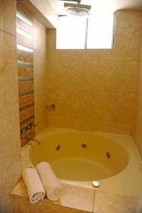 y baño con bañera grande y toallas. en Hotel Waynapicchu, en Cusco