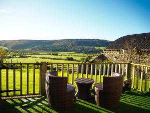 a balcony with chairs and a fence with a view of a field at The Grainary Cottages in Scarborough