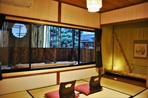 京都市にあるゲストハウス 近江の椅子2脚と大きな窓が備わる客室です。