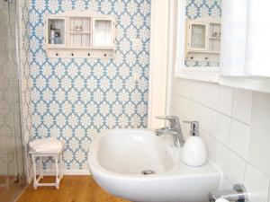 a bathroom with a sink and blue and white tiles at Am Inselufer in Werder