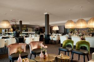 een eetkamer met tafels en stoelen en een restaurant bij Van der Valk Hotel Nazareth-Gent in Nazareth