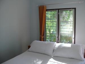 a bedroom with a bed and a window at Suan Bang Bon Guest House in Plai Phraya