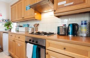 a kitchen with wooden cabinets and a stove top oven at Home2Home-Rooms in London