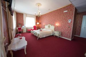 TerzignoにあるHotel Imperialeの赤い壁のベッドルーム1室、ベッド1台、椅子1脚が備わります。