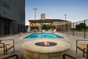 a pool with a fire pit in front of a building at Country Inn & Suites by Radisson, New Braunfels, TX in New Braunfels