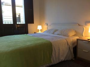カステルフォリット・デ・ラ・ロカにあるCal Mestre - Apartament 4 pax. 1er pisのベッドルーム1室(大型ベッド1台、緑の毛布付)