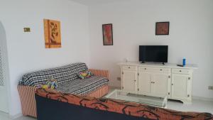 a living room with a couch and a flat screen tv at Viviendas Las Vistas in Puerto del Carmen