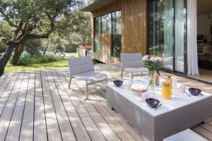 eine Terrasse mit einem Tisch und Stühlen auf einer Terrasse in der Unterkunft Sweet lodges Aix en Provence in Rognes