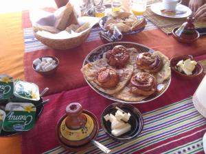 a table topped with plates of pastries and cheese at Palmeraie Guest House in Tinerhir
