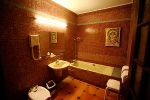 La salle de bains est pourvue d'une baignoire, d'un lavabo et de toilettes. dans l'établissement Hôtel Les Arcades, à Biot