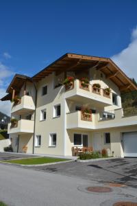 - un immeuble blanc avec des boîtes de fleurs sur les balcons dans l'établissement Alexandra's Apartment, à Neustift im Stubaital