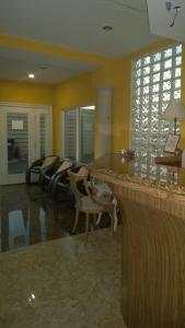 a lobby with a bar with chairs and a table at Solari Casa de Huespedes in Rosarito