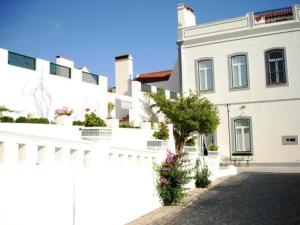 un edificio blanco con una valla blanca y un árbol en Casa Do Lavre, en Lavre