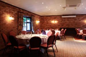 a room with tables and chairs and a brick wall at Blaby Westfield Hotel in Leicester