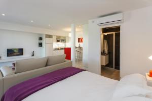 1 dormitorio blanco con 1 cama grande y cocina en Senderos en Villa Gesell