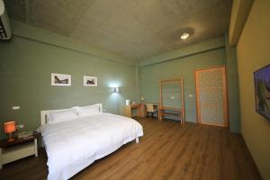 a bedroom with a white bed in a green wall at Country Living Home Stay in Jian