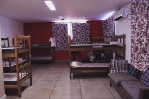 Central Hostel في ريو دي جانيرو: غرفة بها ثلاثة أسرة بطابقين وأريكة