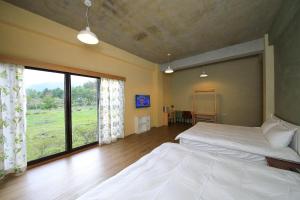a bedroom with two beds and a large window at Country Living Home Stay in Jian