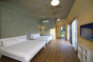 a bedroom with two beds and a flat screen tv at Country Living Home Stay in Jian