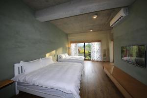 a bedroom with two beds and a large window at Country Living Home Stay in Jian