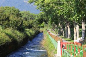 a river with a red fence next to a river at Country Living Home Stay in Jian