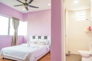 - une chambre violette avec un lit et un ventilateur de plafond dans l'établissement Lavender One Residence Apartment, à Sekinchan