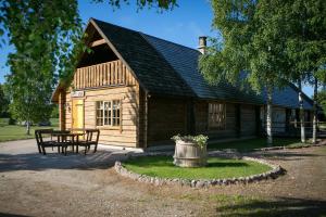 una cabaña de madera con una mesa delante en Holiday Village Suur Töll en Kuressaare