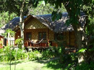 a cottage in the woods with a tree at Relax Bay Resort in Ko Lanta