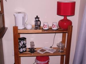 a shelf with a red lamp and other items on it at Annie's BnB at 7C in Renwick