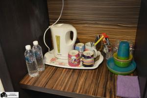 萬津的住宿－ZamLan Gold Coast Morib Intl Resort - Studio，茶壶和茶杯的桌子