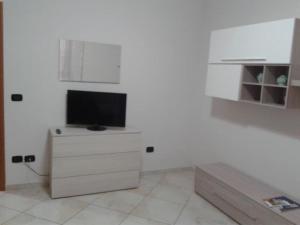 a living room with a tv on a white wall at SWEET HOME GIULIA Locazione ad uso turistico in Cimitile