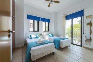 two beds in a room with two windows at Protaras Holiday Villa Alexa in Protaras +35 photos