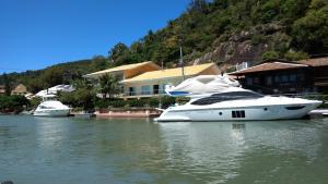 twee boten liggen aangemeerd in het water vlakbij een huis bij Studios Formanabá in Florianópolis