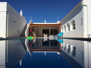 a reflection of a building in a swimming pool at Villa Sunkiss Algarve Carvoeiro in Carvoeiro