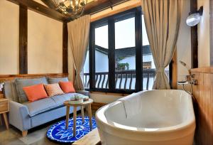 杭州Youxiake Canal Hotel Hangzhou的一间带浴缸和沙发的客厅