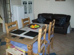 un tavolo con sedie e un cesto di frutta. di Stone Cottage a Ménéac
