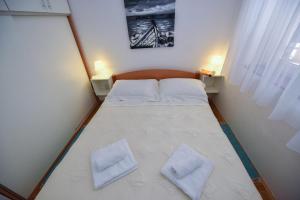 a small bedroom with a bed with two white pillows at Vicy Apartment Novalja in Novalja