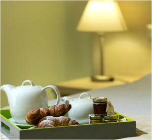 a tray with a tea set and a plate of food at Hotel Tiziano in Trapani