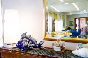 a room with a mirror and a fish statue on a counter at Hotel Riva Del Sole in Cefalù