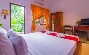 a bedroom with a large white bed with a window at Blossoming Romduol Boutique in Siem Reap