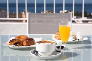 Ona Marbella Inn في مربلة: طاولة مع طعام الإفطار وكوب من عصير البرتقال