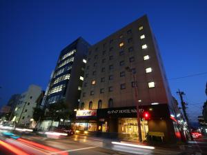 Un palazzo alto in una strada di città di notte di Sentia Hotel Naito a Kōfu