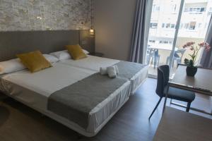 1 dormitorio con cama, mesa y ventana en Ona Marbella Inn en Marbella