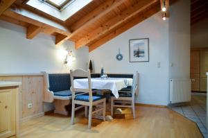 een eetkamer met een witte tafel en stoelen bij Hotel Restaurant Ferienwohnungen ALPENHOF in Übersee