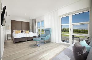 um quarto com uma cama, uma cadeira e uma janela em Hotel Hamar em Borgarnes