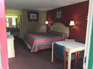 um quarto de hotel com duas camas e uma mesa em Relax Inn em Albany