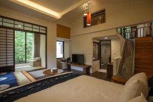 ein Schlafzimmer mit einem Bett und einem Fernseher darin in der Unterkunft Zhou Ye Cottage in Sanyi
