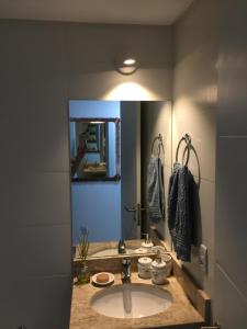 a bathroom with a sink and a mirror at Buenos Aires 605 in Osório