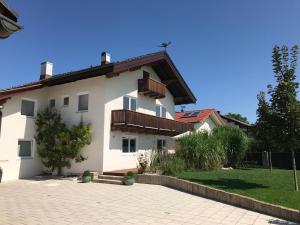 a white house with a balcony and a yard at Gästehaus Grabbe in Prien am Chiemsee