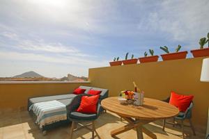 a balcony with a table and chairs and a couch at LA PERLA by RENTMEDANO superb luxury duplex, private roof terrace, ocean view, pool, WiFi and parking in El Médano